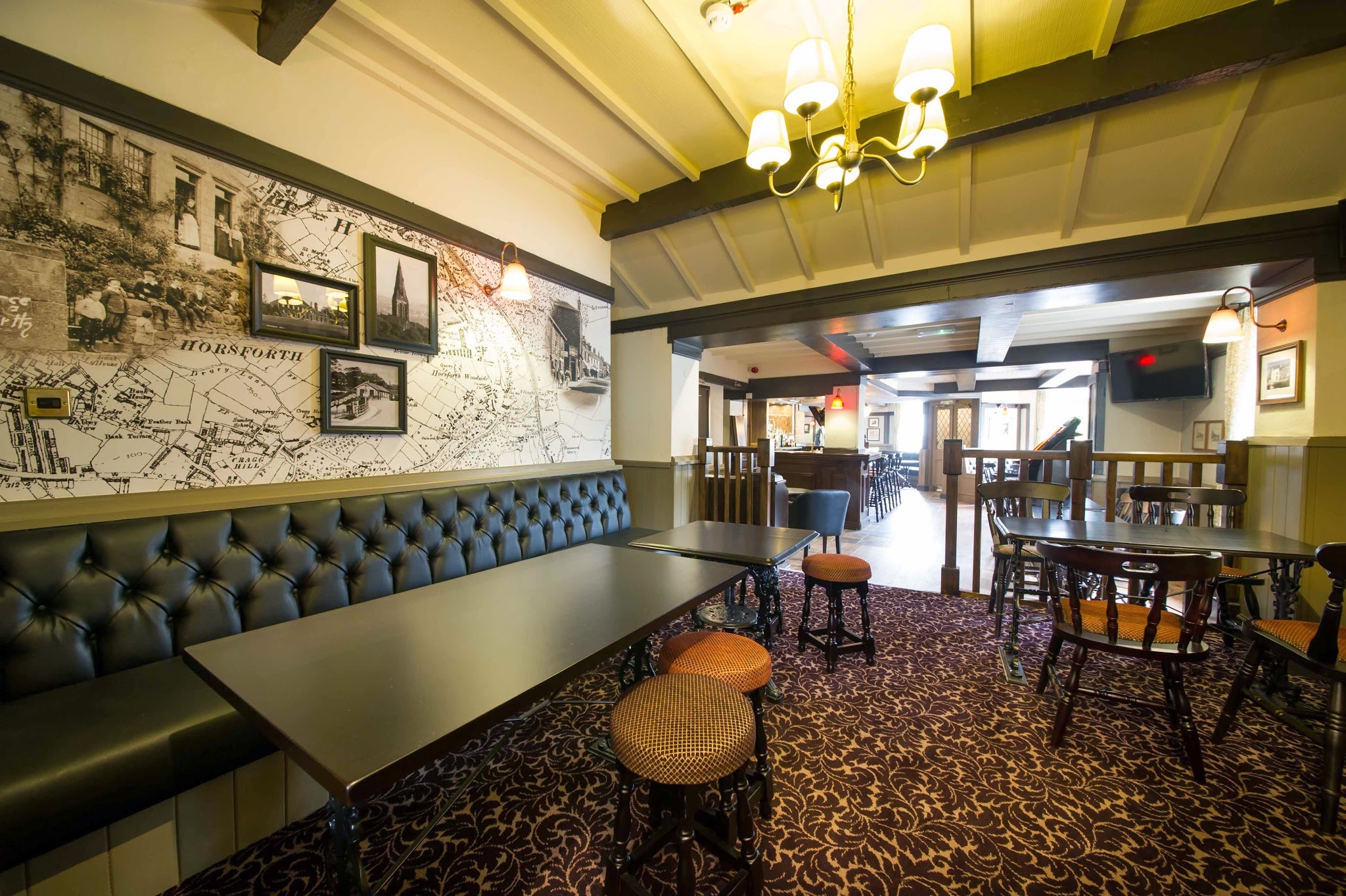 The Bridge's dining room with leather seating, timber beams and a Horsforth history mural